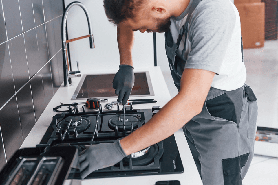 Technician inspecting a gas cooktop